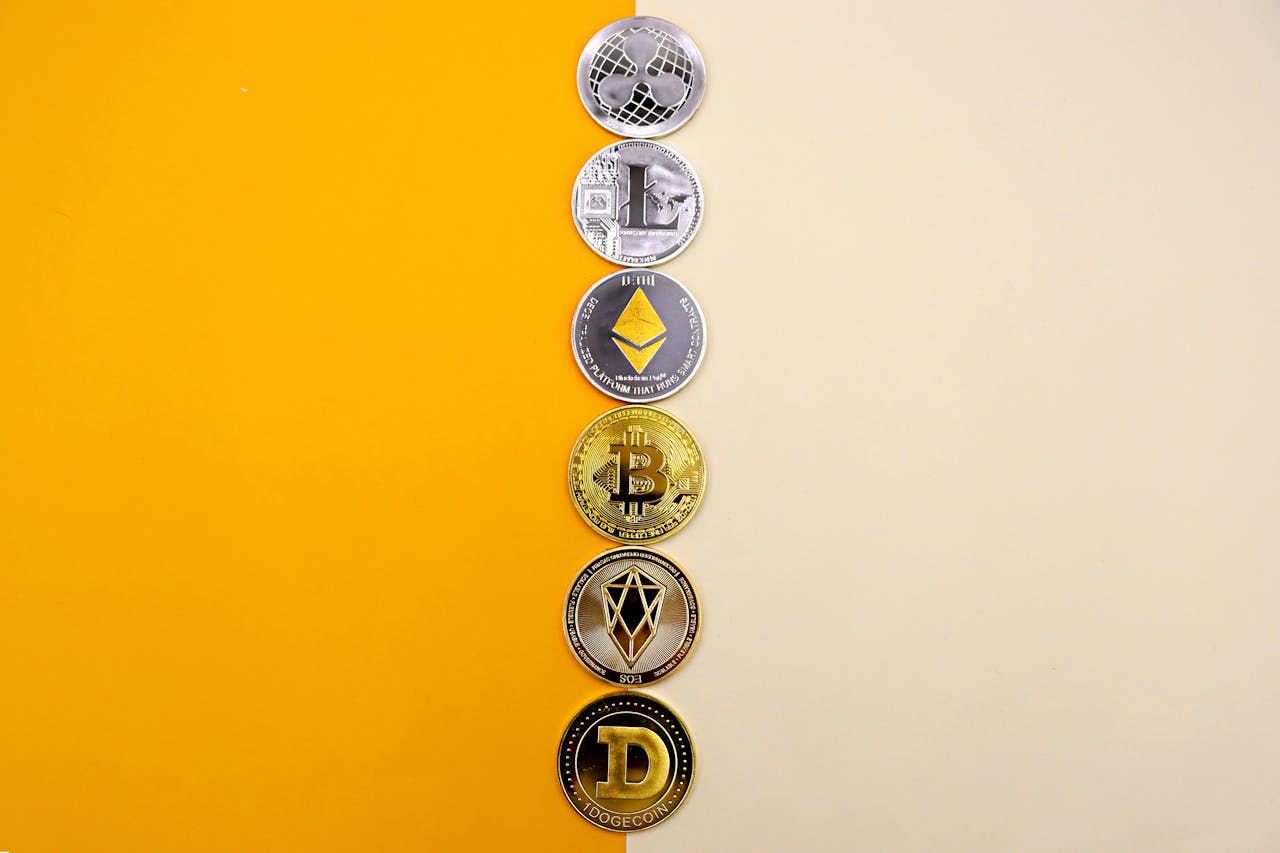 A row of cryptocurrency coins including Bitcoin, Ethereum, and Dogecoin on a vibrant yellow surface.